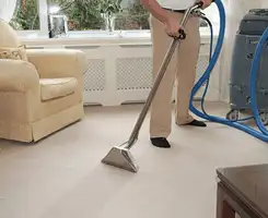 Carpet cleaning professional removing dirt and stains with a hot-water extraction tool in a home, Pittsburgh, PA.