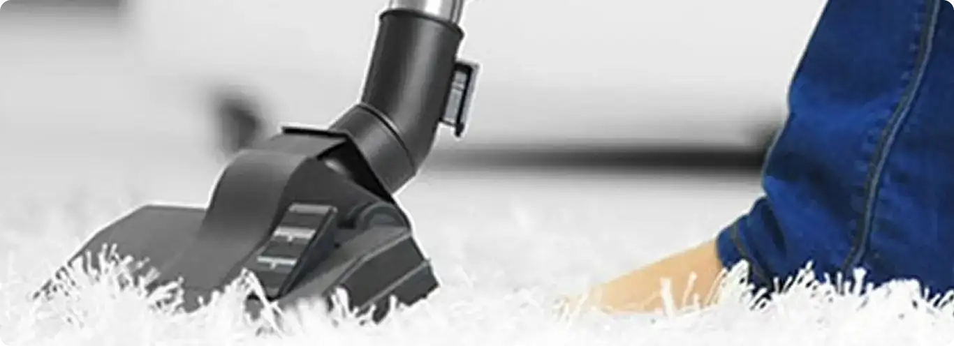 Close-up of a professional vacuuming a white carpet in Mc Kees Rocks.